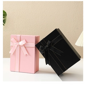 Detail of pink and black foldable gift boxes with elegant ribbon bows and gold edges