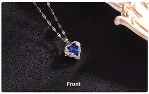 Detail view of heart-shaped dark blue crystal pendant with pave-set white crystals