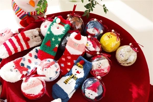 Detailed view of plush coral fleece Christmas socks in a festive holiday gift box