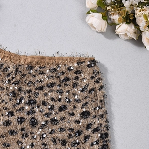 Detail of golden sequin fringe shorts with black leopard spots and elastic waistband
