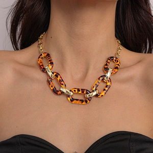 Detail of chunky acrylic leopard print link chain necklace with gold metal accents