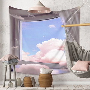Detail of Bohemian tapestry featuring a dreamy pink cloudscape and moon on wall