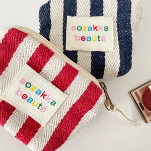 Vertical striped canvas makeup bags in red and navy blue with sozakka beauté label