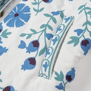 Gros plan détaillé sur l'imprimé floral bleu d'un manteau en coton blanc avec poche