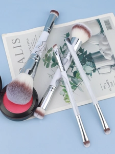 Close-up of dual-head makeup brushes with marble pattern handles and synthetic bristles