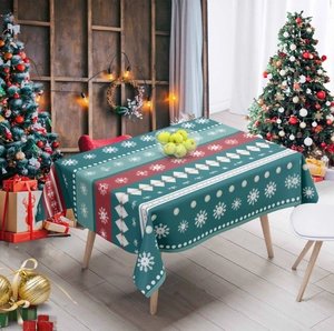 Detailed close-up of festive Christmas tablecloth with snowflake patterns and red border