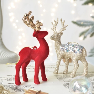 Red flocked Christmas reindeer ornaments with gold glitter antlers on vintage book pages