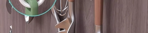 Detail of sliding kitchen cabinet hook in olive green holding various utensils on rack