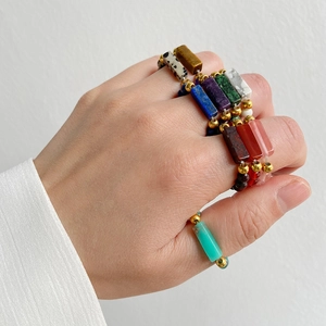 Detail of 4mm natural gemstone beaded rings with gold beads on model hand