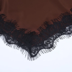 Gros plan sur le tissu en satin marron et la dentelle noire délicate sur le caraco col en V