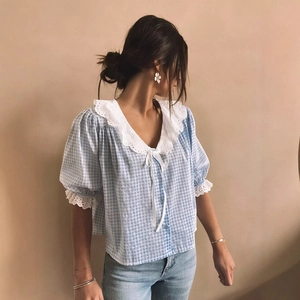 French blue plaid shirt with puff sleeves and lace collar shown on model in studio