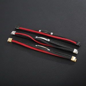 Detailed view of multilayer leather bracelets with black and red braids and magnetic clasps