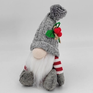 Detail of a Christmas gnome with grey knitted hat, artificial berries, and a white plush beard
