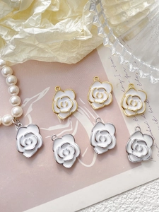 Detailed view of white enamel rose charms with gold and silver edges for jewelry making
