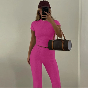 Dettaglio del set due pezzi rosa acceso con top corto aderente e pantaloni a vita alta