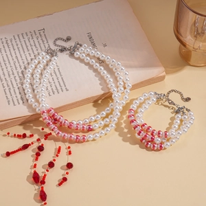 Collier à trois rangs de perles avec accents de marbre rouge et pampilles style vintage
