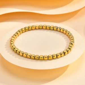 Detailed view of square gold cube beads on a minimalist metallic strand bracelet