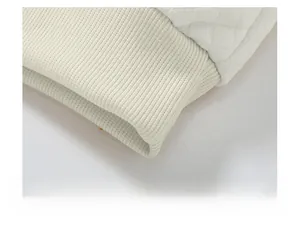 Makroaufnahme von elfenbeinfarbener Steppung und Rippstricksaum am Sweatshirt