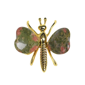 Golden butterfly brooch with polished unakite wings on a clean white background