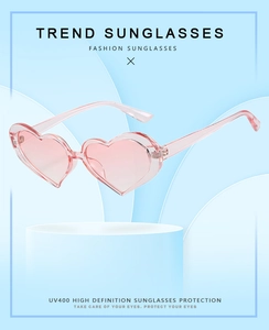 Detail of pink heart-shaped sunglasses with UV400 protection and matching frame