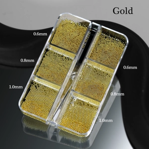 Macro view of gold nail art caviar beads in 0.6mm to 1.0mm sizes in a six-grid box