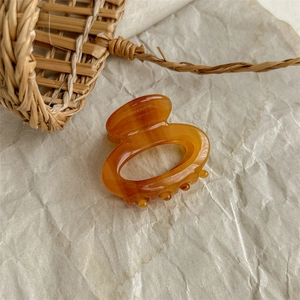 Close-up of amber acetate hair claw clip featuring the France Handmade engraving details