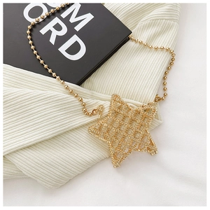Detailed close-up of a star-shaped hollow metal bag with a sleek golden mesh design