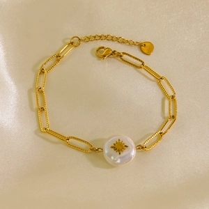 Baroque pearl bracelet with starburst motif and gold rectangle link chain on silk