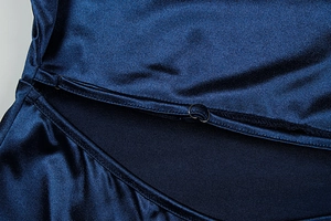 Detail of adjustable metal buckle and stitching on navy blue satin halter dress strap