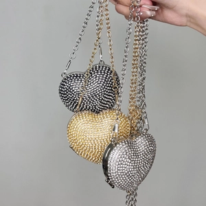Close-up of heart-shaped rhinestone mini bags in dark grey, gold and silver finishes
