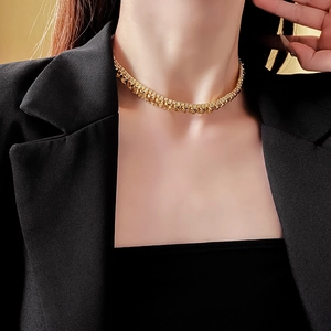 Close-up of a gold square pendant necklace with diamonds worn by a professional model