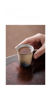 Détail d'une tasse à thé en céramique artisanale avec texture de montagne et thé