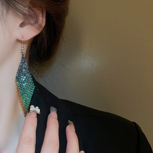 Gros plan sur des boucles d'oreilles losange de luxe avec cristaux dégradés bleu et vert