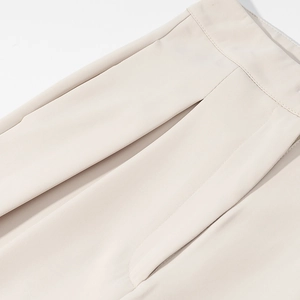 Detailed close-up of beige trousers showing side pocket and high-quality seam stitching