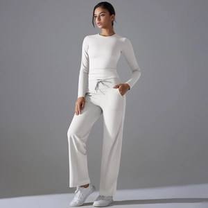 Détail d'un ensemble de yoga blanc avec haut manches longues et pantalon large taille haute