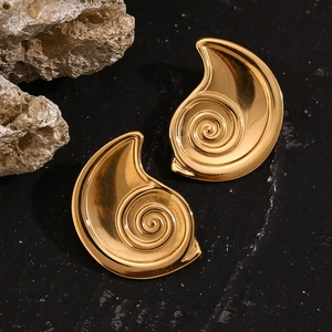 Macro shot of 18K gold-plated cochlea spiral stud earrings on a dark textured background