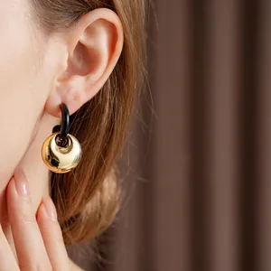 Luxury geometric black and gold dangle earrings with a minimalist mirror finish sphere