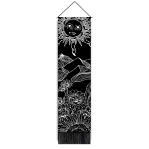 Detail of bohemian black and white tapestry with sun, mountains, and tassel trim