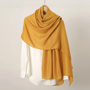 Solid yellow cotton linen scarf for women hanging elegantly against a neutral background