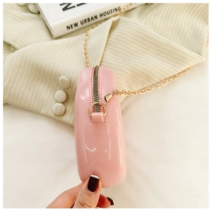 Close-up of pink jelly mini bag with gold chain strap and polished PVC texture