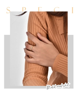 Detail of 18K gold plated minimalist ring with three zircon stones on model's index finger