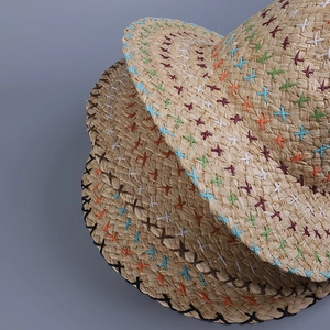 Close-up of bohemian straw hats with colorful cross-stitch embroidery on the brim