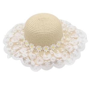 Detail of baby girl straw hat with white lace floral brim and daisy flower accents