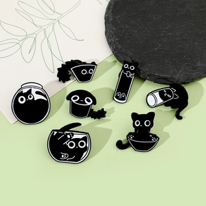 Detailed set of seven cartoon black cat enamel pins displayed on a light green background