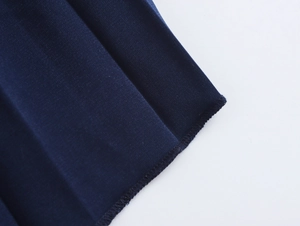 Detail of dark blue satin fabric with elegant pleated texture and clean edge stitching