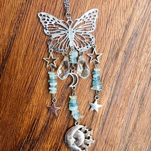Detailed shot of silver butterfly suncatcher with blue crystals and moon pendant