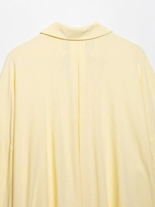 Detailed view of back pleats and collar on light yellow linen blend wide sleeve shirt