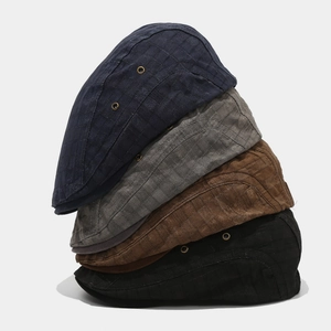 Retro plaid flat caps in navy, grey, brown, and black with metal eyelets for ventilation