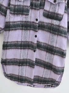 Close-up of purple plaid wool coat featuring black buttons and symmetrical flap chest pockets
