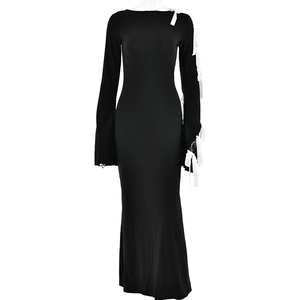 Detail of elegant black dress featuring white bow tie accents on off-shoulder sleeves
